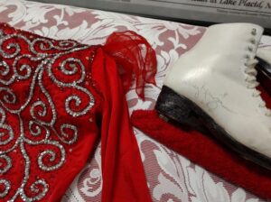 Close up view of a red sequined skating costume and skates signed by Olympian Nancy Kerrigan