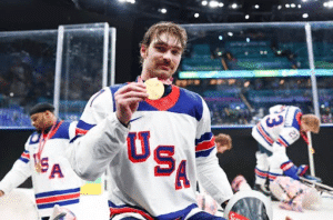 David Eustace posing with his 2nd Paralympic Sled Hockey Gold Medal.